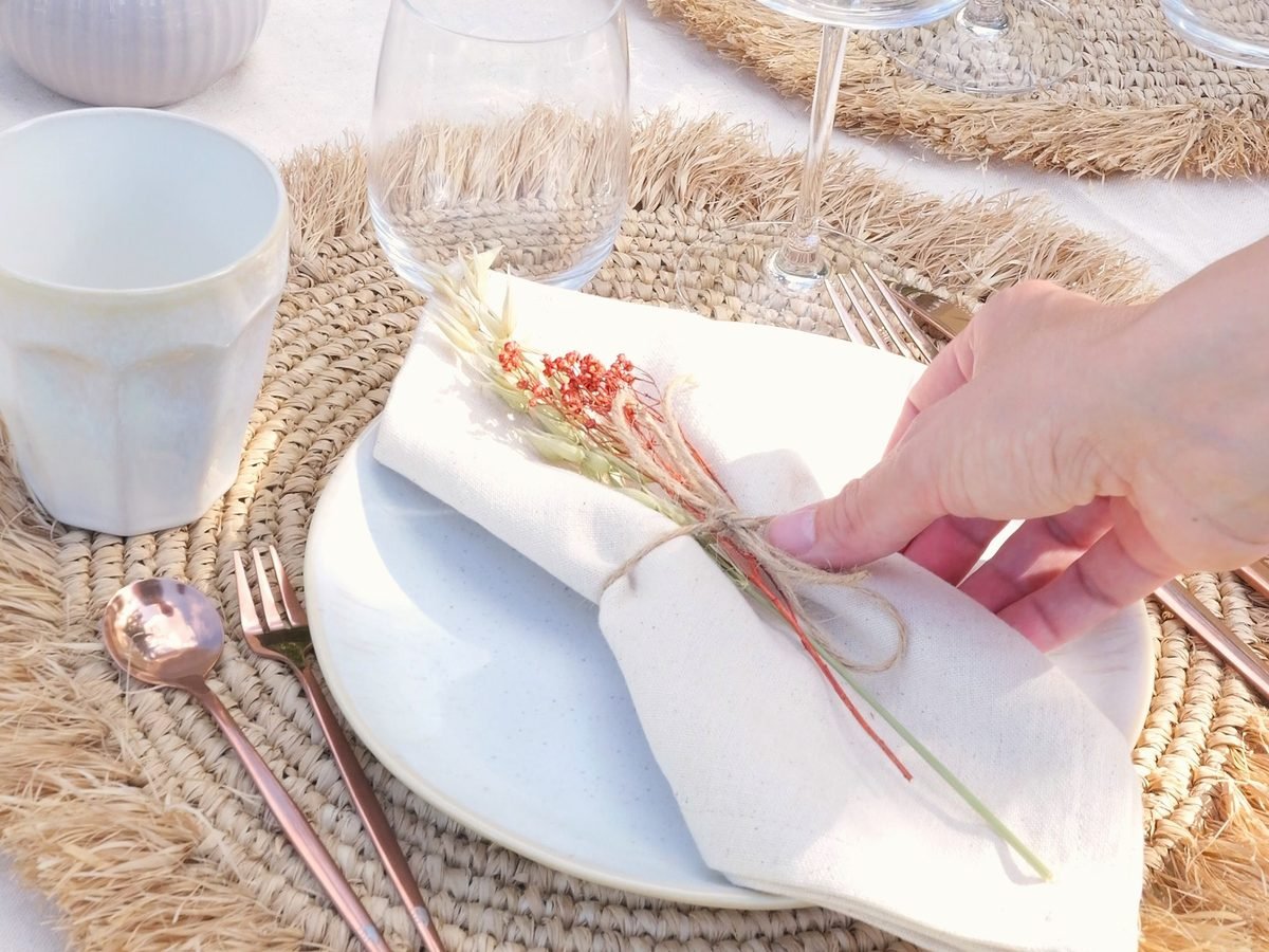 Liebevoll dekoriertes Gedeck mit Stoffserviette und Trockenblumen